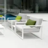 Sophisticated Royal Botania Ninix lounge chair with white coated steel frame and light gray Batyline seat, complemented by square green pillows