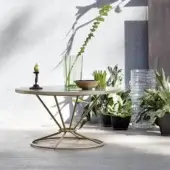 Elegant Roberti Rattan Gravity coffee table with round aluminum top and striking stainless steel base in beige-tan finish