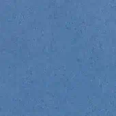 Medium blue fabric sample with dense, granular texture and matte finish, displaying a uniform speckled appearance and consistent coloration.