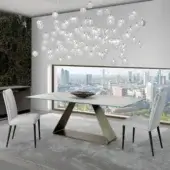 Refined Reflex Oh table with bent metal base in satin bronze and expansive Marble glass tabletop