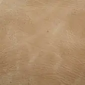 Zebu rye leather texture displaying a tan color with natural grain, creases, and circular markings against a neutral backdrop.