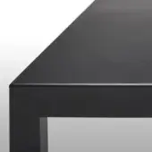 Black iron table with goeffered matte finish, squared edge, and rectangular leg in studio lighting against white gradient backdrop.