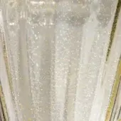 Murano glass vase, clear with gold flecks, features vertical rigato polvere oro ridges and a subtly faceted upper edge.