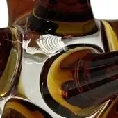 Murano glass sculpture, amber and brown, swirling organic form with layered curves, etched fan detail, glossy finish, white background.