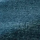 Teal Rugiano Tempesta rug with dense looped pile, gradient color from turquoise to deep teal, matte finish, and textured, uneven surface.