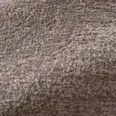 Rugiano ciottolo rug, gray-brown textured fabric, rounded pebble-like surface with granular, uneven composition and studio lighting.