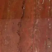 Rugiano indoor rug, reddish-brown travertine texture, with a central vertical crack revealing dark fissures and mottled beige-rust veining.