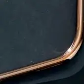 Rectangular panel with dark mottled surface and polished copper metal frame, featuring rounded edges and a circular indentation.