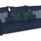 Navy blue fabric sofa with wide armrests, featuring solid & patterned pillows—geometric green, woven white & gray—low profile, studio shot.