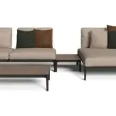Modular sectional sofa, dark gray metal frame, light beige textured fabric upholstery, with brown and green pillows, and wood-like coffee table.