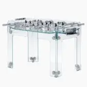 Foosball table, transparent acrylic and chrome, with horizontal rods, plastic players, circular bases, and mesh netting on a white background.