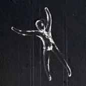 Crystal sculpture, transparent human figure, leaping pose suspended by wires against dark textured wall, Terzani Angel Falls.