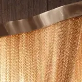 Terzani Atlantis pendant light, brushed champagne finish, featuring a vertically textured metallic mesh and curved reflective band.