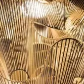 Terzani Moire chandelier, gold plated, features concentric rods in a radiating web-like pattern with reflective highlights and dramatic lighting.