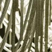 Bronze chain link curtain, vertical strands, layered metallic texture, warm muted tones, Terzani Volver brushed bronze detail.