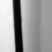 Abstract composition of dark gray textured stripe against blurred white and gray background, featuring fibrous pattern and matte finish.