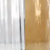 Plastic film sheets, translucent and golden-brown, display vertical striations, wrinkles, and torn edges with subtle "vistosi" text.