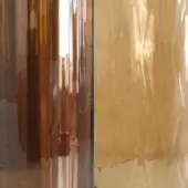 Vistosi glass samples, copper and gold iridescent sheets with rippled texture, torn edges, displaying brushed metal reflections.