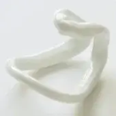 Ceramic dish, white glazed, sculptural looping form with a square basin and smooth, rounded contours against a white backdrop.