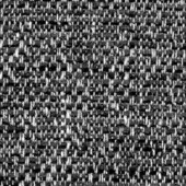 Gray tweed fabric texture displaying a dense, irregular plain weave with visible silver and charcoal threads and a fabric code label.