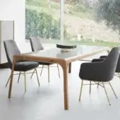 Distinguished Presotto Relevè table with sculpted light-toned wood legs and a smooth glossy clear glass tabletop