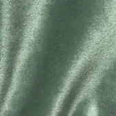 Green velour fabric texture with a plush, dense pile and subtle sheen, displaying linear shadows and the text “vismara brilliant velour ve23”.
