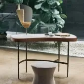 Refined Bonaldo Venus vanity with dark metal legs and a curved base supporting a light-colored ceramic top within a wooden frame