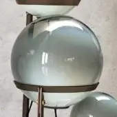 Floor lamp, dark bronze metal, three smoked glass globes with gradient blue-gray tint, minimalist design, vertical rods, angular supports.