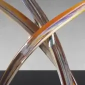 Stainless steel table base with curved metal tubes and iridescent amber, gold, violet dichroic glass sections, geometric design.