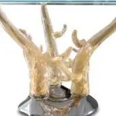 Glass table with gold corallo base, featuring a clear circular top and complex, branching amber-toned sculptural support in a studio setting.