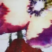 Cream textile sample with watercolor pattern in burgundy, olive, and purple hues, featuring blurred edges and a tight weave.