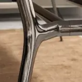 Black nickel table frame with curved tubular metal elements, polished glossy finish, intersecting joints, and reflective highlights.