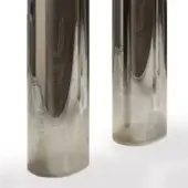 Silver cylindrical sculptures with a sputtering gradient finish, suspended against a white backdrop, showcasing reflective metallic texture.