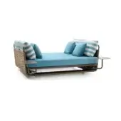 Outdoor daybed with rattan frame, turquoise upholstery, and striped pillows, paired with a matching woven side table on a white background.