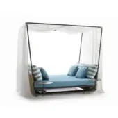 Day bed, wicker and metal, with blue cushions and canopy; white studio backdrop, paired with circular side tables.