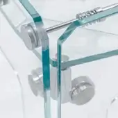 Clear glass table with brushed metal connectors, featuring thick rectangular panels and cylindrical supports, secured with a horizontal rod.