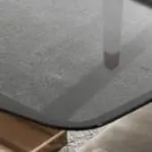 Fumé tempered glass table with dark gray cat, dark brown border, and speckled granite-like composite base, diffused lighting.