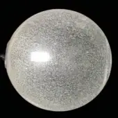 Clear quartz orb with internal reflective particles, dark metal mount, and subtle textural variations against a black background.