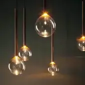 Elegant Bonaldo Sofi lamp with a warm amber borosilicate glass globe and burnished brass cylinder