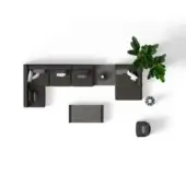 Dark gray sectional sofa with chaise, white pillows, and rectangular coffee table, plus green plant and woven ottoman.