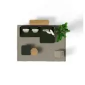 Modular sofa, dark green fabric, with white pillows, styled on gray rug with palm, wood table, and glass accent table in studio setting.
