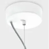 Circular canopy light, matte white finish, flush-mounted to light gray wall with single silver cable and subtle textured surface.