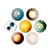 Glass spheres in teal, amber, and brown arranged circularly, featuring translucent cores and bubble-like indentations on a white background.