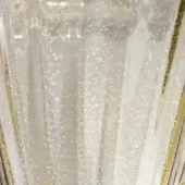Clear glass vase with vertical ribbed texture and scattered gold flecks, featuring a subtly scalloped rim and transparent finish.