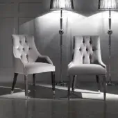 Exceptional DV Home Collection Byron chair with matte grey textile and button-tufted backrest built with dark-toned wood legs capped in silver metal