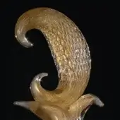 Glass sculpture, amber-gold translucent glass, swirling upward form with silver threads, rounded base, glossy finish, studio lighting.