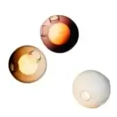 Blown glass wall sconces, amber, smoky brown, and white, featuring circular apertures in contrasting orange and yellow tones, staggered arrangement.