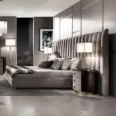 Lavish DV Home Collection Hermes bed with quilted headboard and dark wood bedside tables in gold accents