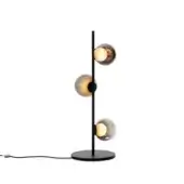 Floor lamp, matte black metal, slender cylindrical stem with three spherical shades in amber and smoky gray gradients, warm internal light.