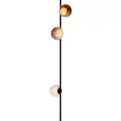 Floor lamp, black metal, with three hand-blown glass globes in amber, peach, and white tones, slender pole, minimalist design.